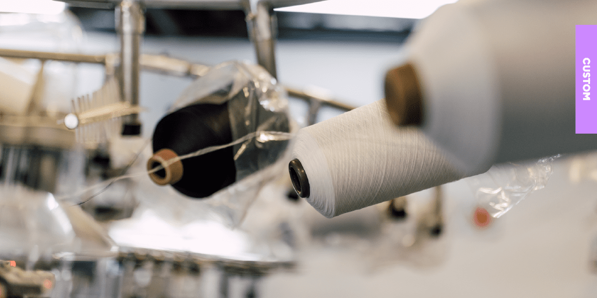 Rolls of PolyLon36 yarn on the manufacturing line, illustrating the sustainable and durable material used for The Sox Factory's high-performance custom socks.