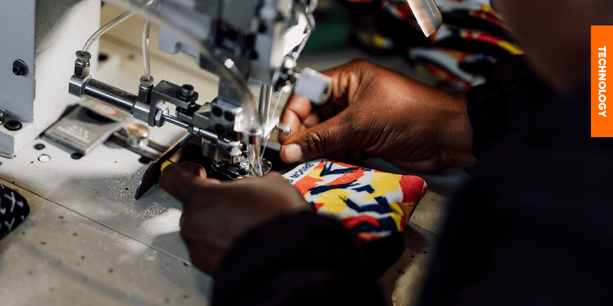A close-up of an operator using a tagging machine to attach header cards with biodegradable yarn, replacing plastic kimbles for eco-friendly packaging.